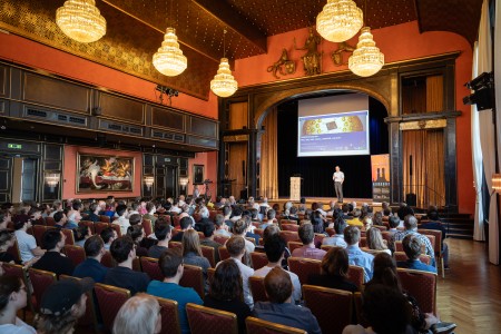 Audience sitting in aneorenaissance hall for a public talk on quantum computing. 