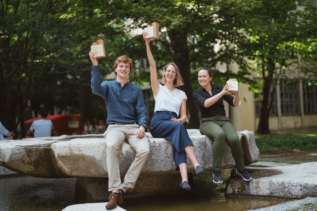 Three researchers posing with the wooden Nano Innovation Award.