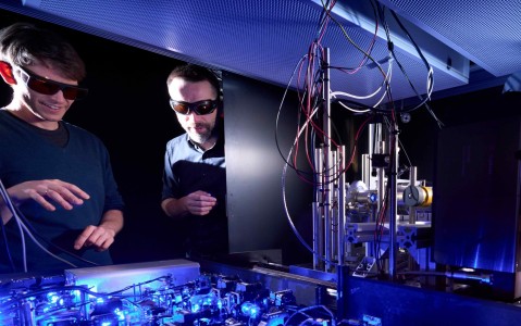 Analog quantum simulator Prof. Johannes Zeiher (left) in the laboratory with typical setups for a quantum simulation experiment,